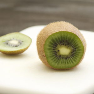 kiwi fruit sliced on a white cutting board